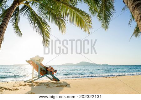 Beautiful Woman on the beach at the tropical summer resort underthe coconut tree