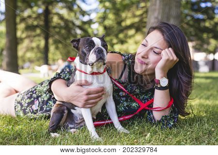 A woman with terrier dog outside at the park