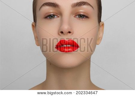 The woman with brightly red full lips. Fashion damp shadows for eyes and red lipstick a long neck and pure leather. Increase in lips correction of eyebrows injections cosmetology and make-up