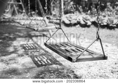 Empty swings on playground.wings in city park. Empty chain swings in summer kids children playground.