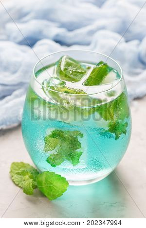 Trendy blue moscato wine in a glass served with mint ice cubes vertical