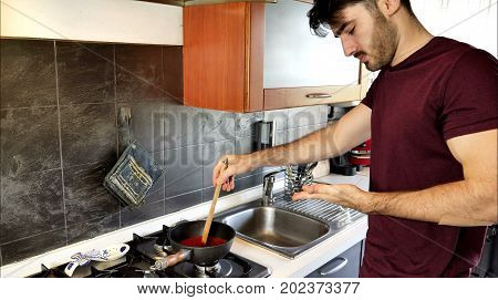 Man getting burn injury while cooking on kitchen at home.