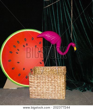 Background with a pink flamingo on a dark green background. Flamingo watermelon. woven baskets. Flamingo