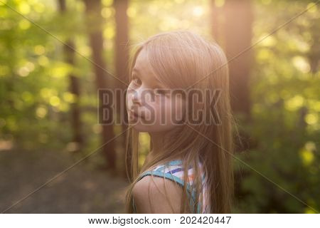 A nice child girl on green forest