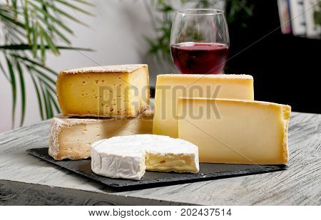 Different french cheeses with a glass of red wine