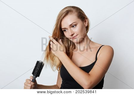 Picture Of Beautiful Blonde Female Taking Care Of Her Hair, Combing It After Taking Shower, Isolated