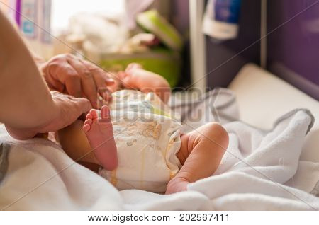 Person Changing Baby Diaper Of The Dada Biedronka Brand On A Changing Table On August 2017 In Poznan