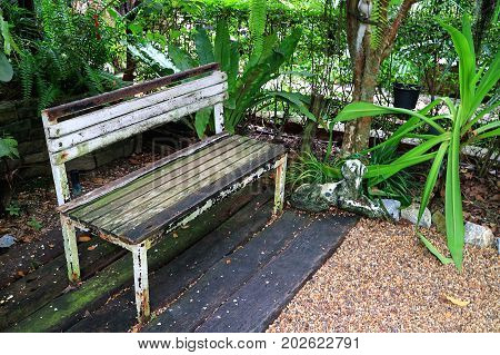White colored old wooden bench in the garden