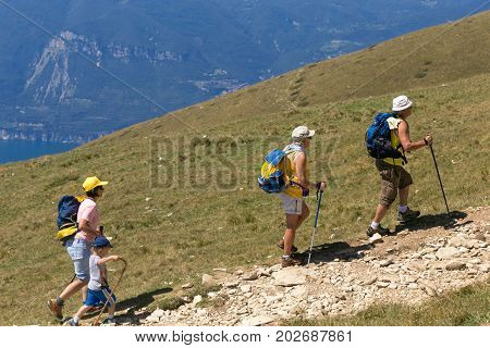 Mount Baldo Italy - August 15 2017: Walking family climbing the mountain