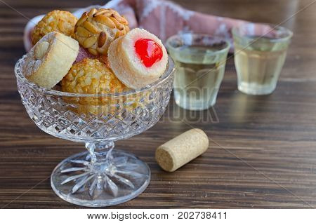 Different Panellets with two glass of sweet vine. Typical sweets consumed at All Saints Day (Dia Todos Los Santos) in Catalonia Spain. Catalan small cakes background.