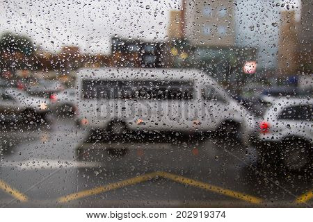Background of moving rain drops on a window glass in a rainy day. Auto