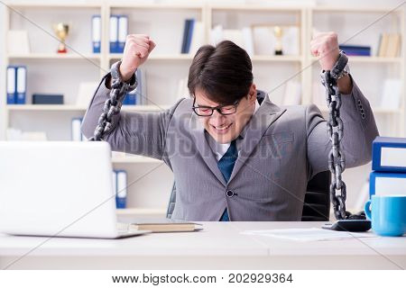 Businessman tied with chains to his work