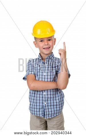 Handsome happy future builder dressed in blue checkred shirt, grey jeans and yellow helmet, gesturing on white background