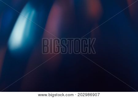 Abstract background of blurs in motion on black. Bokeh of defocused reflection blurred lights on dark backdrop, mirror-like surface, magic nature around