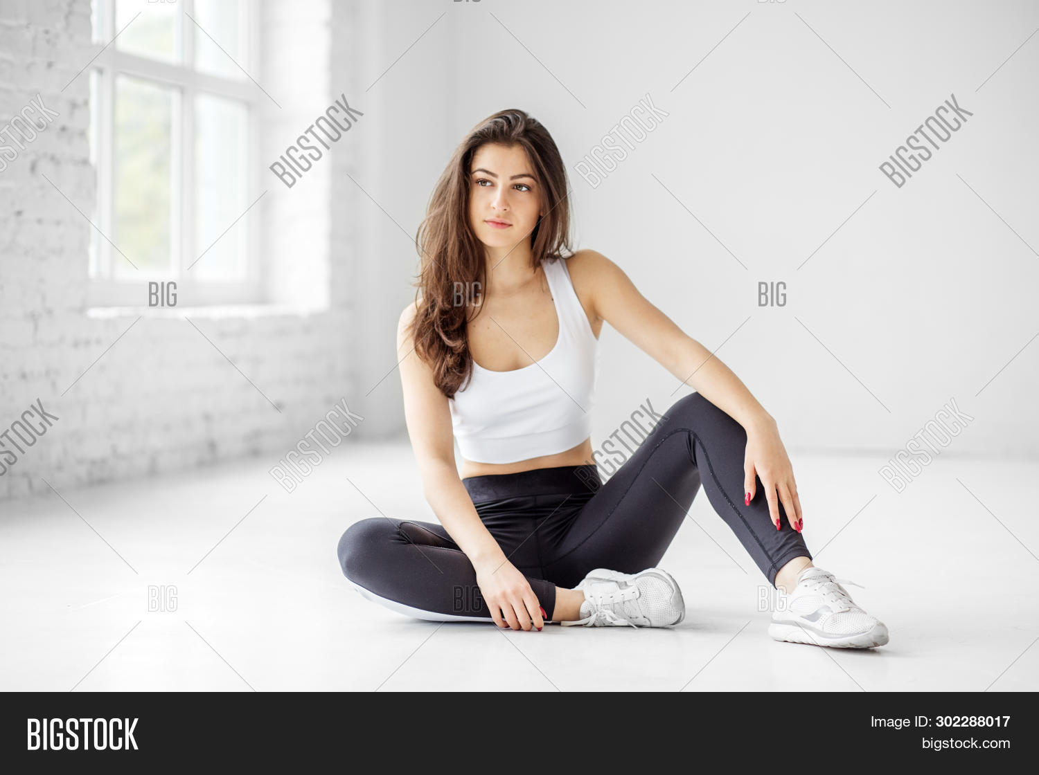 спортивная девушка сидит на полу. спортивные девушки. девушки сидят в зале. девушка в спортзале отдыхает. девушка и фитнес.