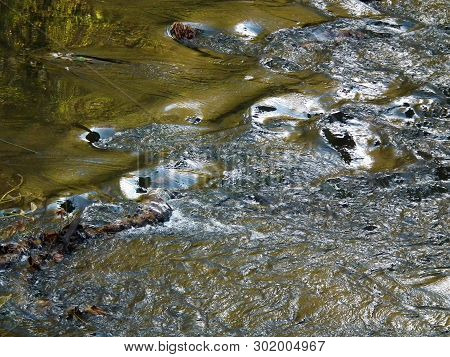 Beautiful Picture Created By The Water, Breaking Through The Stones Protruding From The Bottom Of Th