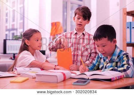 Three Smart Children Making Their Classwork Together.