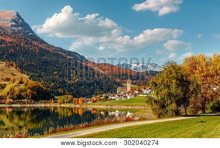 Awesome Alpine Highlands And Mountain Lake Resia In Sunny Day. Impressively Beautiful Autumn Of Ital