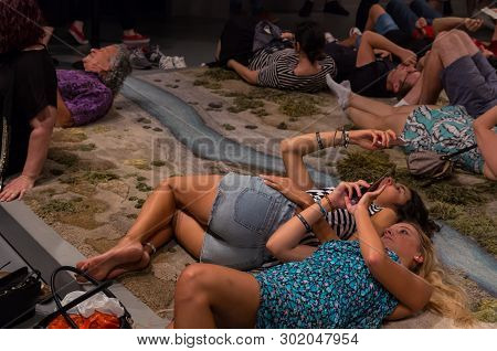 Melbourne, Australia - March 17, 2018: Visitors Resting On The Hand Tufted Wool Rug Entitled Santa C