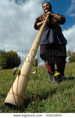 Oude vrouw spelen de traditionele Roemeense alpenhorn