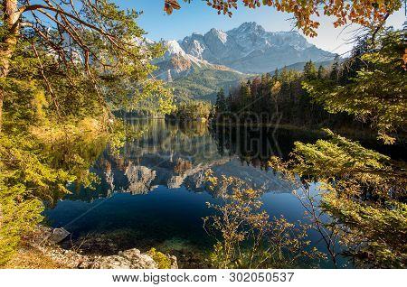 Alpine Landscape With Perfect Sky, With The German Alps Mountains Reflected In The Eibsee Lake On A 