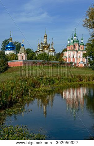 Sts. Peter And Paul Church Of Trinity Monastery  Reflecting In Water. Blue Sky In The Background.