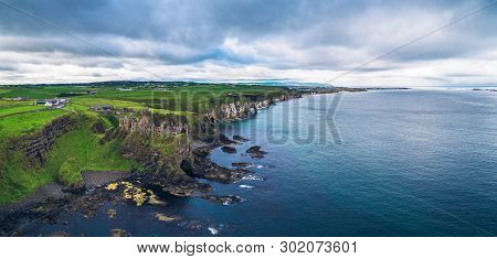 Aerial Panorama Of The Medieval Dunluce Castle Ruins And Surrounding Cliffs In Ireland