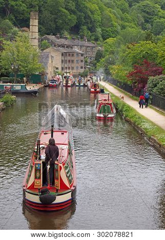 Hebden Bridge, West Yorkshire, England - 19 May 2019: Woman Steering An Old Barge Going To The Histo