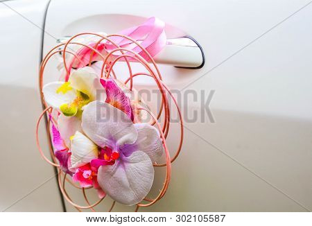 Orchids On A Wedding Car. Composition Of White Orchids On A White Car