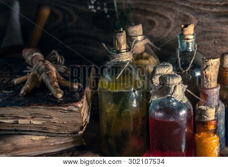 A Witchery Stuff: Multiple Tincture Bottles, Bunches Of Dry Healthy Herbs, Stack Of Ancient Ritual T