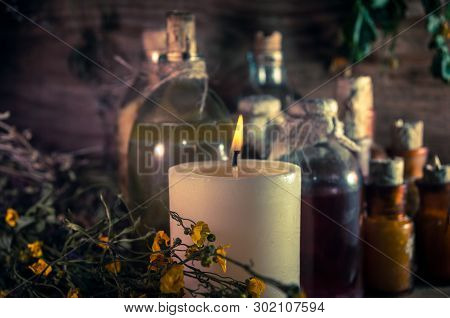 A Witchery Stuff: Multiple Tincture Bottles, Bunches Of Dry Healthy Herbs, Stack Of Ancient Ritual T