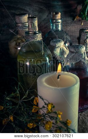 A Witchery Stuff: Multiple Tincture Bottles, Bunches Of Dry Healthy Herbs, Stack Of Ancient Ritual B