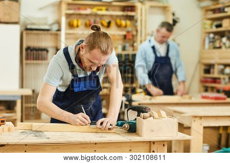 Portrait Of Two Carpenters Working With Wood Standing At Tables In Workshop, Copy Space