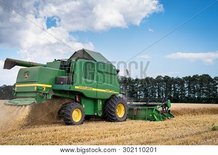 Dobrich, Bulgaria - July 08: Modern John Deere Combine Harvesting Grain In The Field Near The Town D