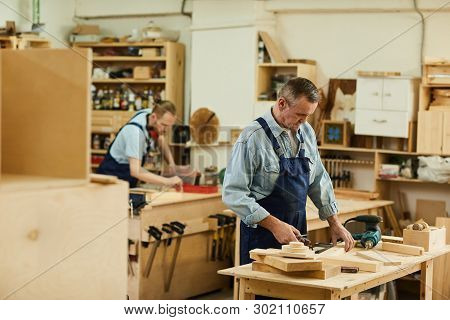 Portrait Of Two Carpenters Working With Wood White Assembling Furniture In Workshop, Copy Space