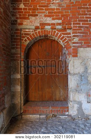 Brown Wooden Door With Padlock In The Medieval Red Brick Wall St. Nicholas Gate Tower Of The Zaraysk