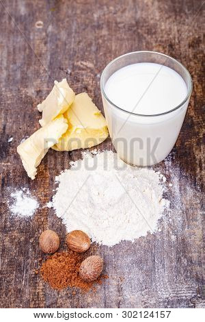 Ingredients For Preparing White Bechamel Sauce On Wooden Table. Close Up