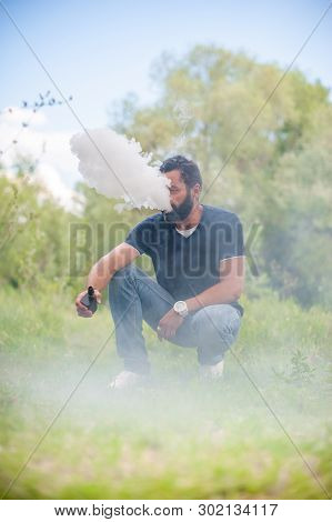 Stylish Man Exhales Cloud Of Smoke. Handsome Man.