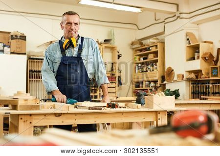 Waist Up Portrait Of Senior Carpenter Looking Away While Working In Joinery, Copy Space
