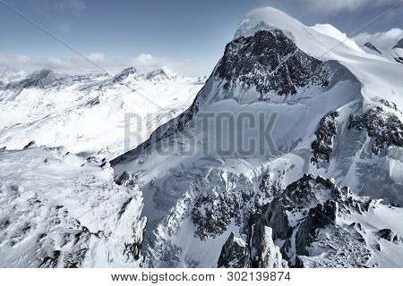 Landscape Of Snow-capped Alpine Peaks In Switzerland. Rocks And Stones Under Snow And Glaciers In Qu