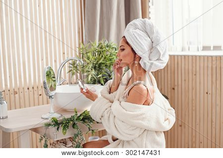 Attravtive Girl Uses Sponge For Own Makeup In The Morning At Bathroom. Beauty Concept.