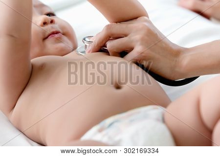 Pediatrics Doctor Examining Heartbeat And Lungs Of Little Baby Boy With Instruments Stethoscope, Hea