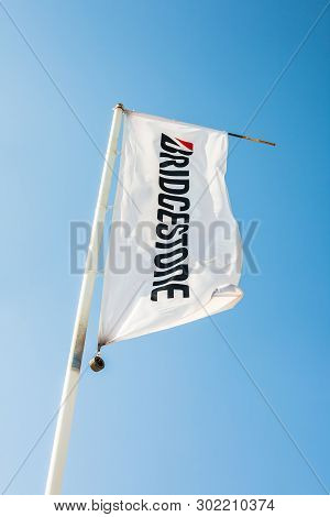 Sagunto, Spain - February 18, 2019: Bridgestone Flag With Logo On Clear Blue Sky Background Located 