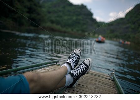 Man Relaxing And Enjoying Landscapes With Limestone Mountains During The Water Tour In Trang An, Vie
