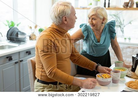 Happy Contended Beaming Nice-appealing Attractive Elderly Spouses Talking During Breakfast