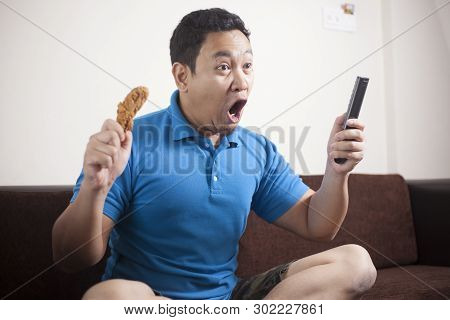Asian Man Watching Soccer On Tv