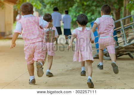 Back View Of Kindergarten Students Run Back To The Classroom After Having Lunch.