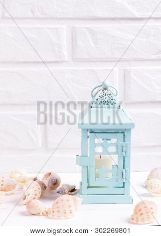Marine Summer  Decorations Near By White Brick Wall. Decorative  Blue  Candleholder With Burning Can