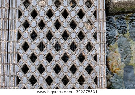 Iron Coverplate Over Streaming Water In Freiburg, Germany