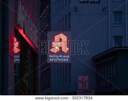 Augsburg, Germany - May 5, 2019: German Pharmacy Sign Illuminated With Red Led Lights